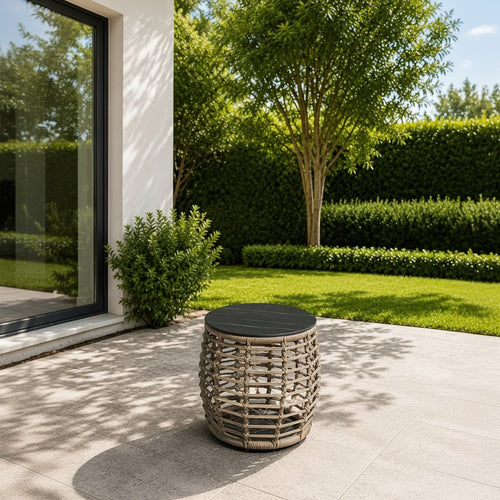 Rattan outdoor side table with black stone top on patio, perfect for garden or balcony decor