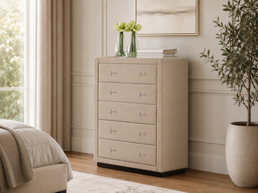 Beige fabric chest of drawers with silver knobs in modern bedroom, styled with vases and books