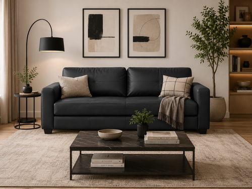 Modern black leather sofa with throw pillows and blanket in stylish living room setup