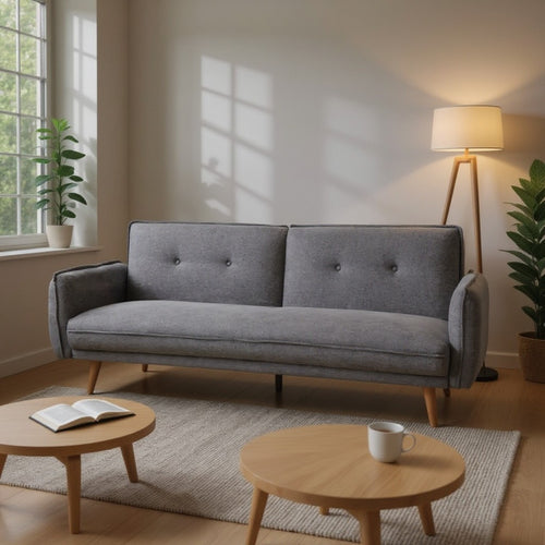 Gray tufted sofa with wooden legs in modern living room, paired with round coffee tables and floor lamp