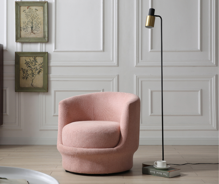 Modern pink upholstered swivel accent chair in a living room with floor lamp and wall art