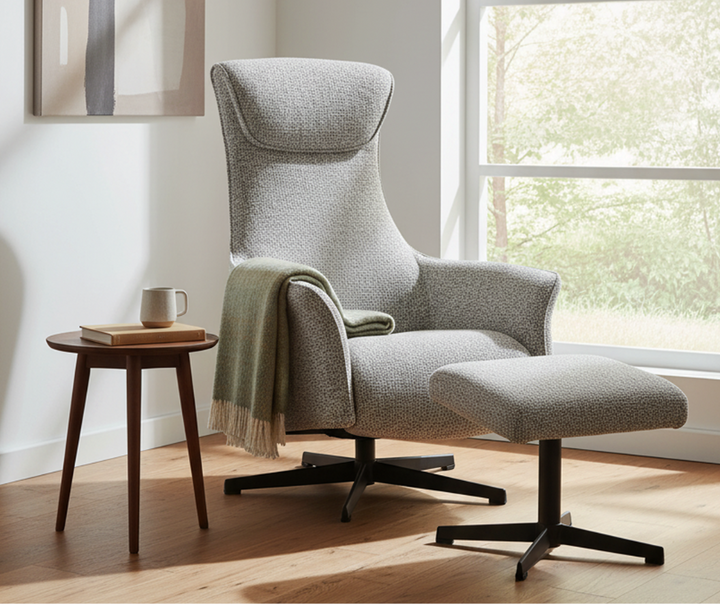 Modern upholstered lounge chair with ottoman, side table, and green throw in sunlit living room