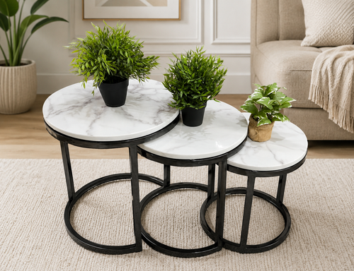 Marble-top nesting tables with black metal frames, styled with green plants in a modern living room