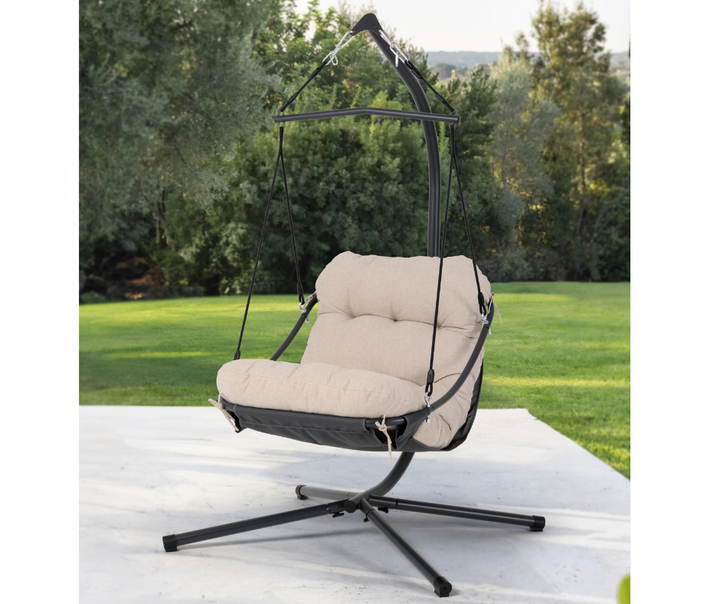 Beige cushioned hanging chair with black metal frame on patio, outdoor garden furniture