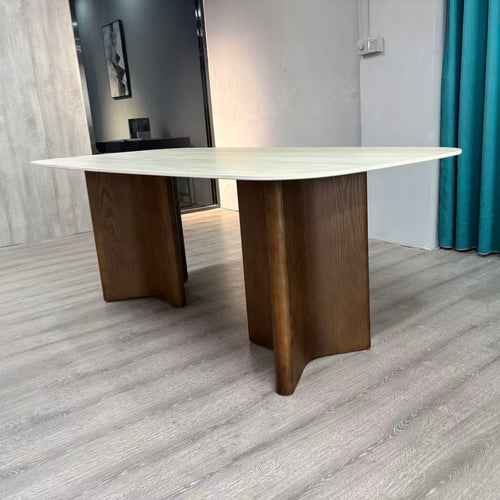 Modern rectangular dining table with light wood top and dark wood legs in a minimalist room