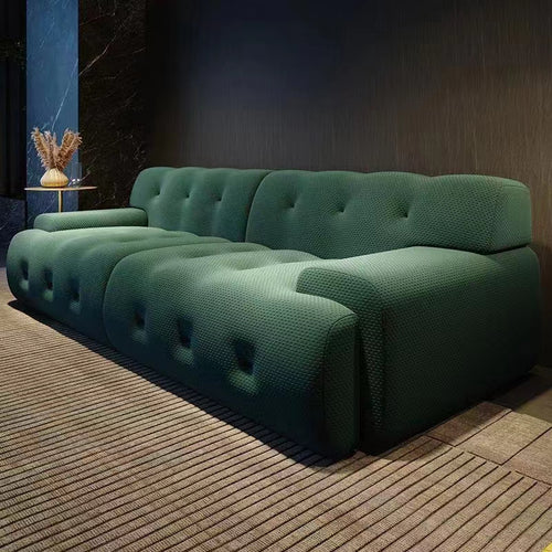 Green tufted modern sofa with textured fabric in contemporary living room setting
