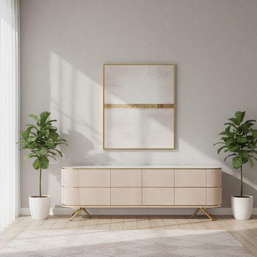 Modern beige sideboard with gold legs, flanked by potted plants under abstract art in bright living room