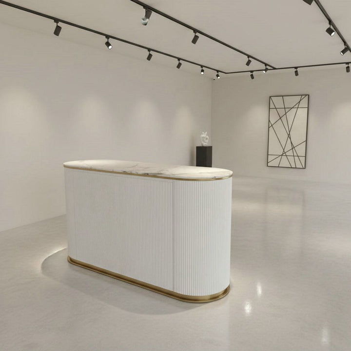 Modern white marble-top reception desk with gold trim in minimalist showroom
