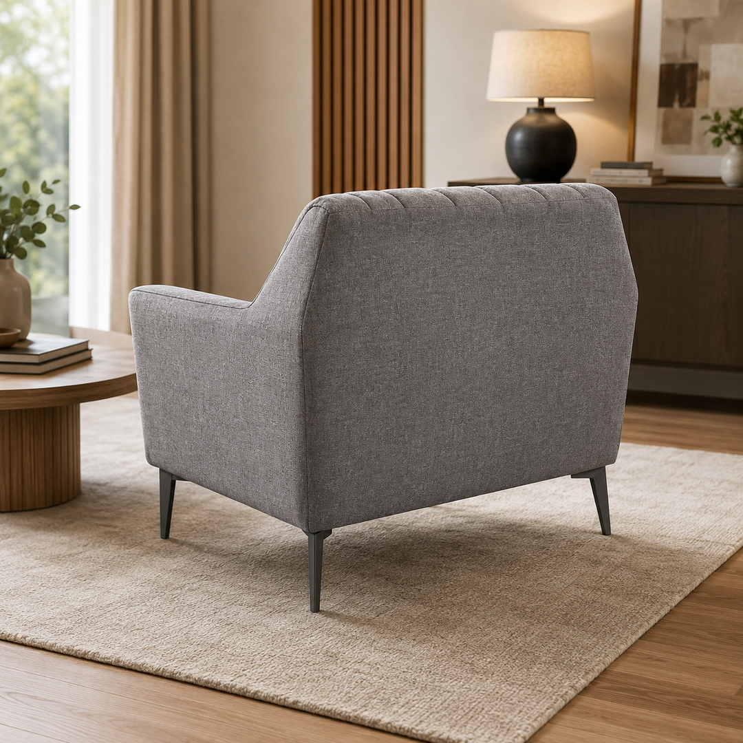 Modern gray fabric armchair with tufted back and black legs in a cozy living room setting