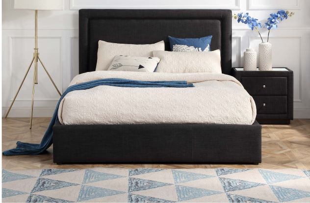 Charcoal upholstered gas lift bed with cream bedding, nightstand, and modern decor
