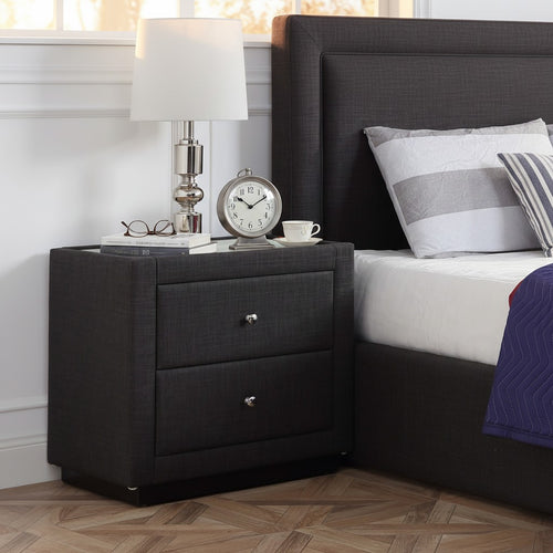 Modern dark gray upholstered nightstand with lamp, clock, and books in bedroom