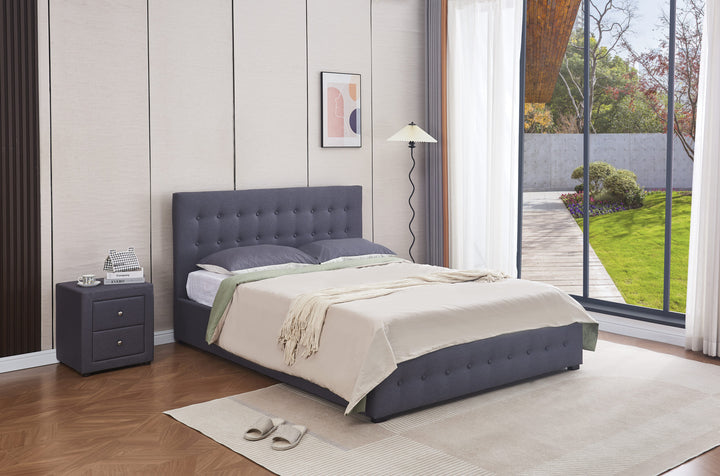 Modern grey upholstered gas lift storage bed in bright bedroom with large window and nightstand