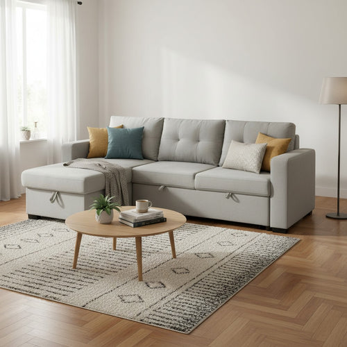 Modern gray sectional sofa with storage chaise, styled in living room with coffee table and rug