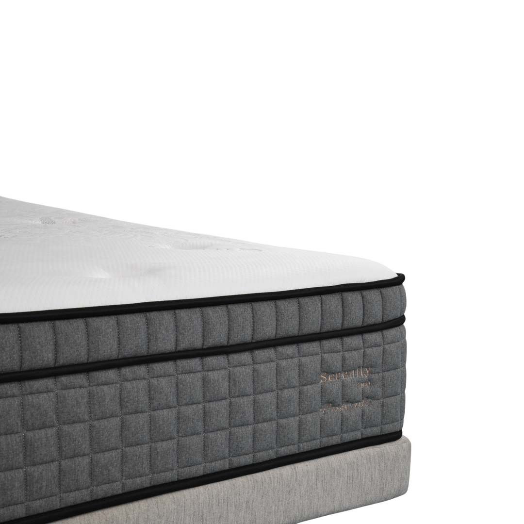 Close-up of a modern grey and white luxury mattress with quilted sides and embroidered details.