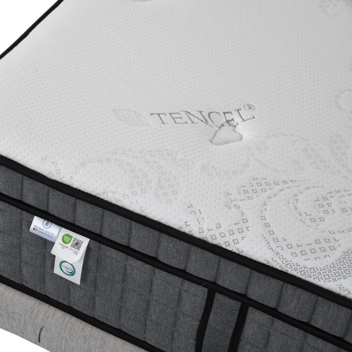 Close-up of a grey and white Tencel fabric mattress with tags and textured surface
