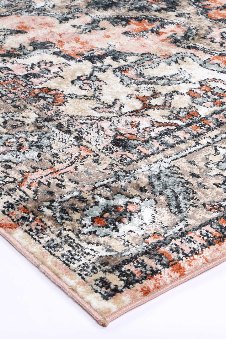 Beige and orange distressed area rug with vintage floral pattern, close-up corner view