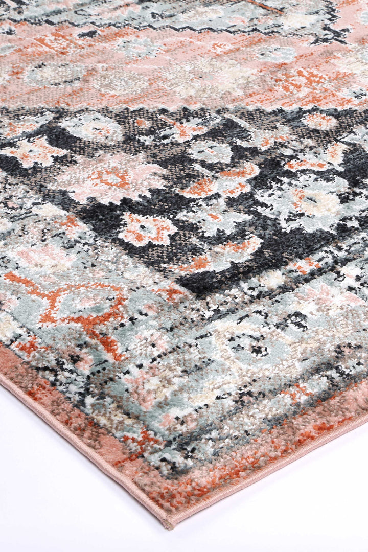 Beige area rug with abstract floral pattern in peach, grey, and black tones on white background