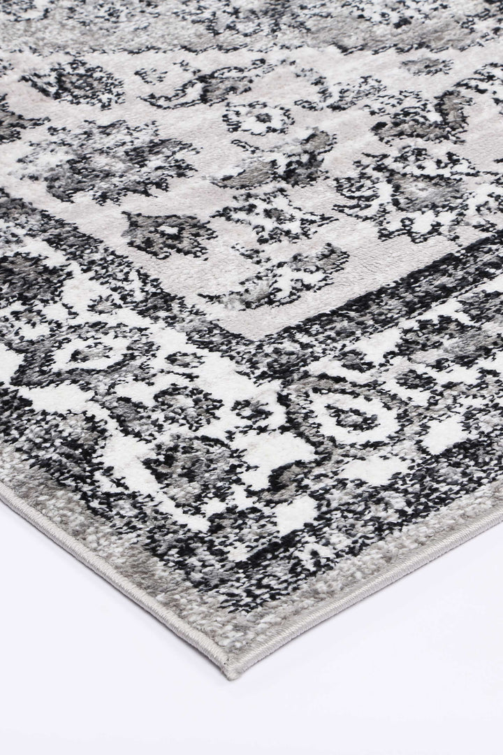 Close-up of a grey and white area rug with a detailed floral pattern
