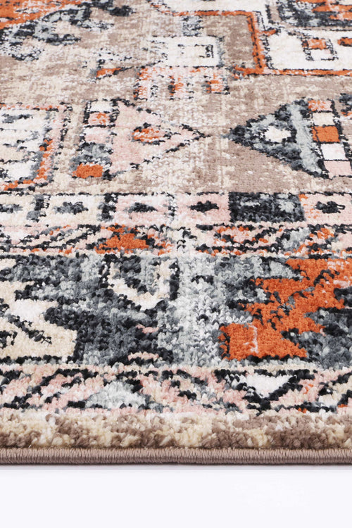 Close-up of a beige, orange, and black geometric patterned area rug with plush texture