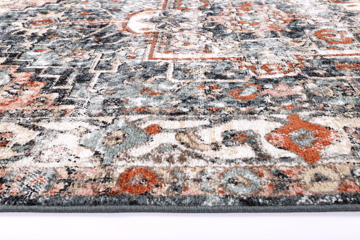 Close-up of a multicolor vintage patterned area rug with orange, blue, and beige accents