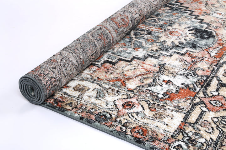 Rolled vintage-style area rug with geometric and floral patterns in earthy colors
