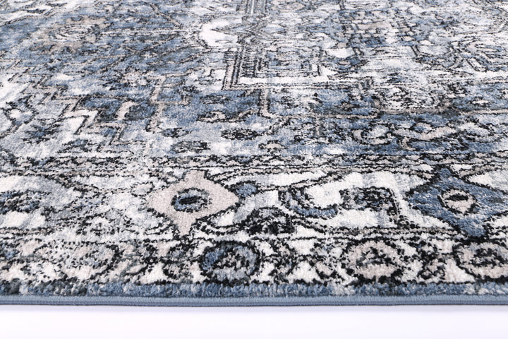 Blue and grey area rug with intricate geometric and vintage pattern close-up
