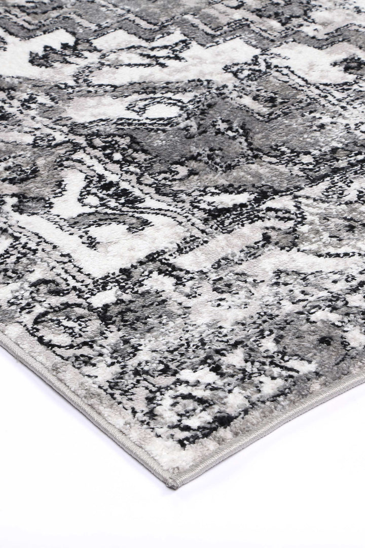 Grey and white area rug with abstract geometric pattern, soft textured surface
