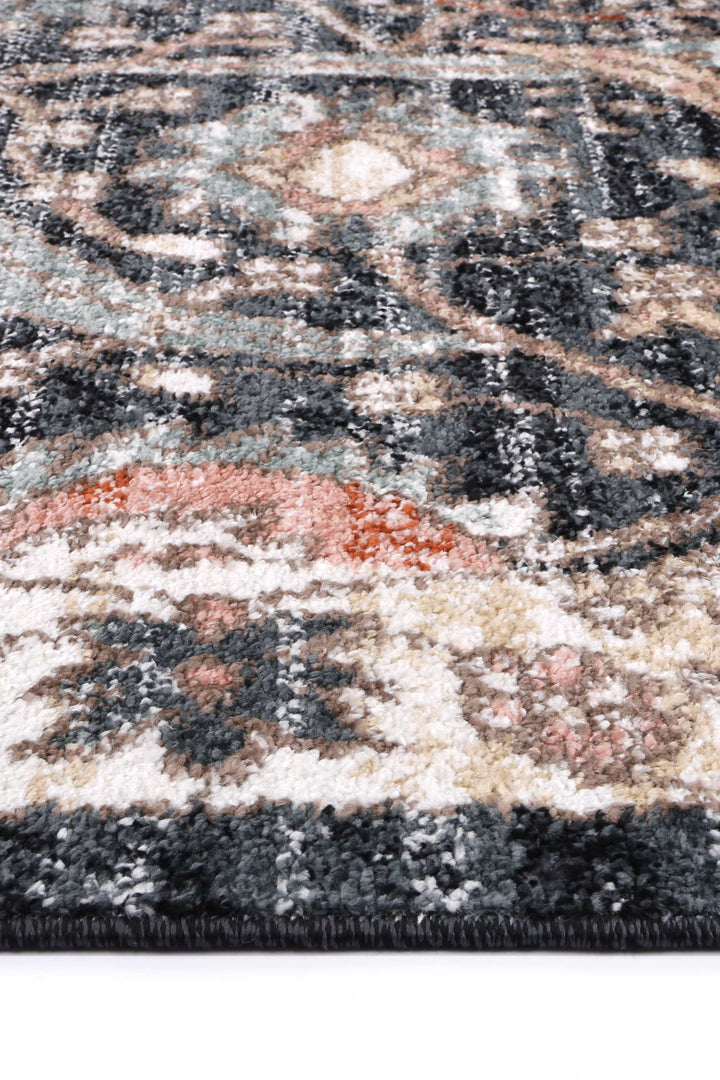 Close-up of a modern patterned area rug with soft textured pile in muted grey, cream, and orange tones