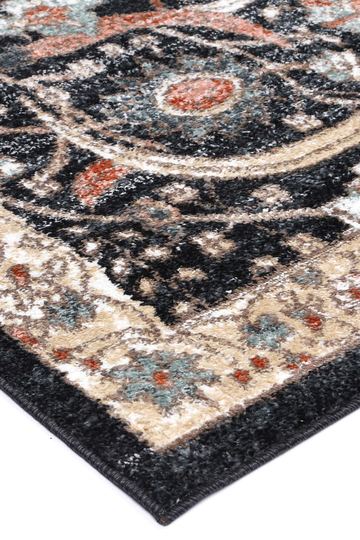 Close-up of a patterned area rug with floral motifs in black, beige, red, and blue tones