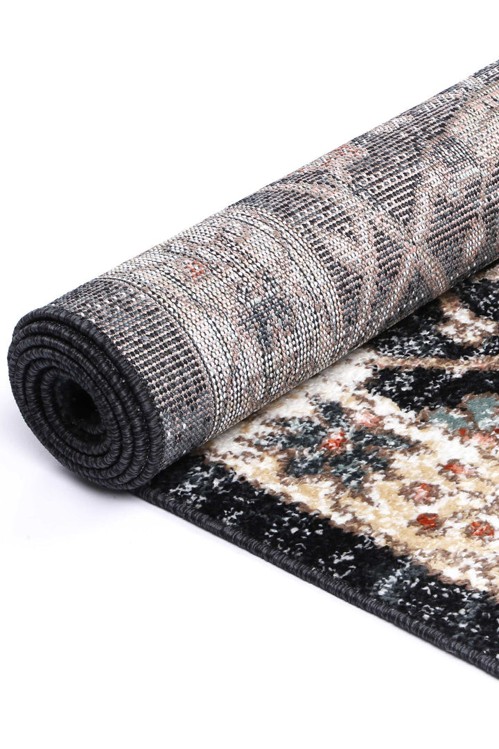 Rolled patterned area rug with textured multicolor design, close-up view