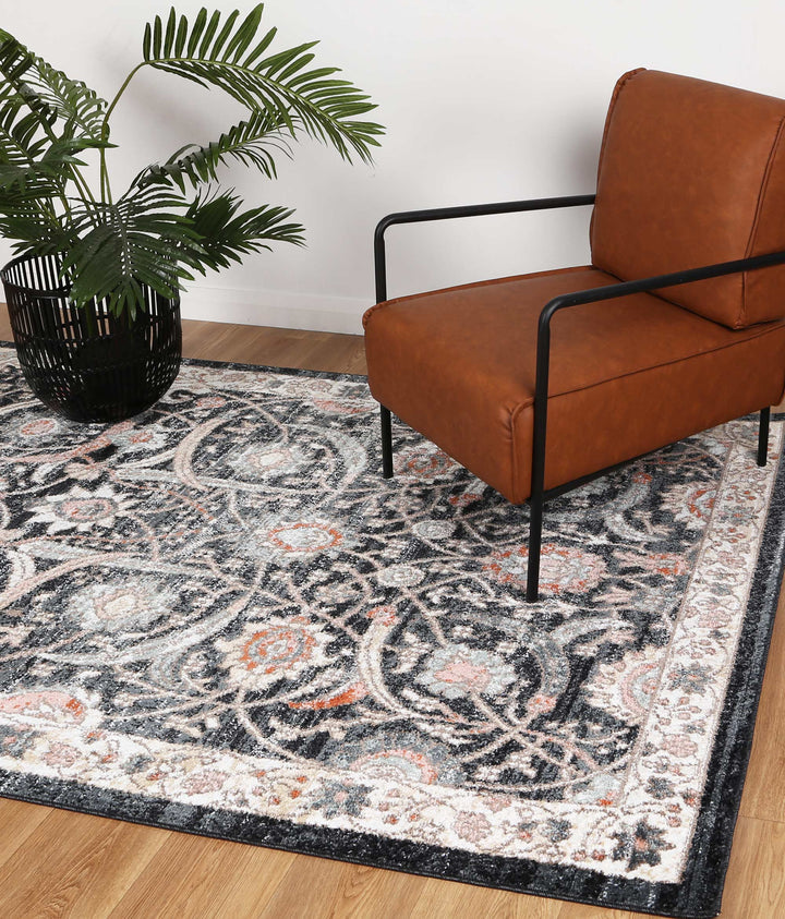 Modern brown armchair on patterned area rug with potted plant, hardwood floor setting