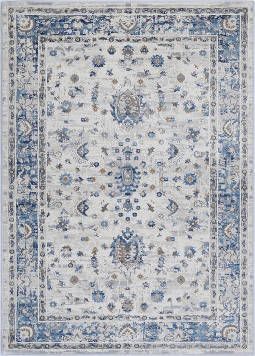 Traditional area rug with intricate blue, ivory, and beige floral patterns and ornate border