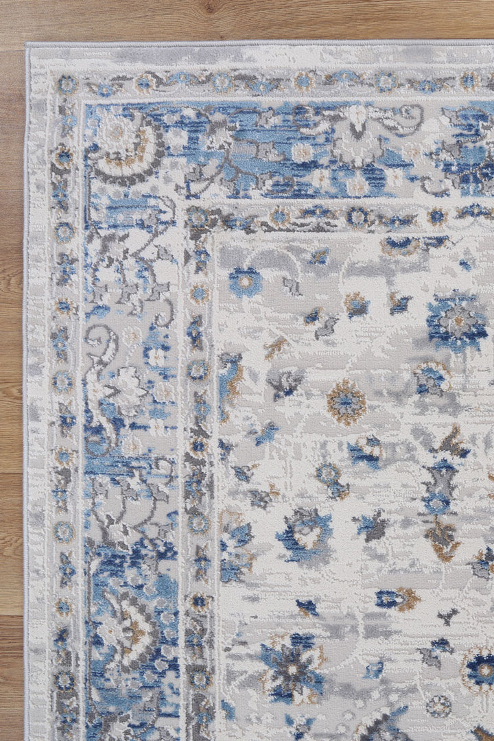Blue and grey floral area rug with intricate pattern on wood floor