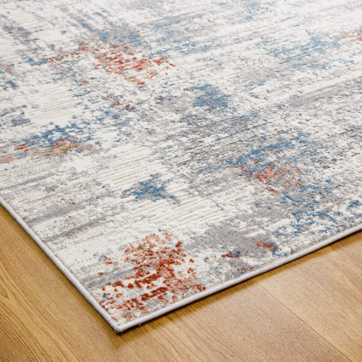 Modern abstract area rug with blue, orange, and gray patterns on wood floor