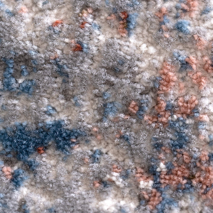 Close-up of soft, textured area rug with blue, grey, and rust-colored patterns
