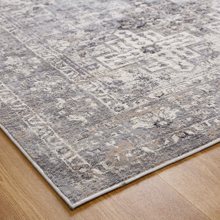 Textured grey and beige area rug with geometric patterns on hardwood floor