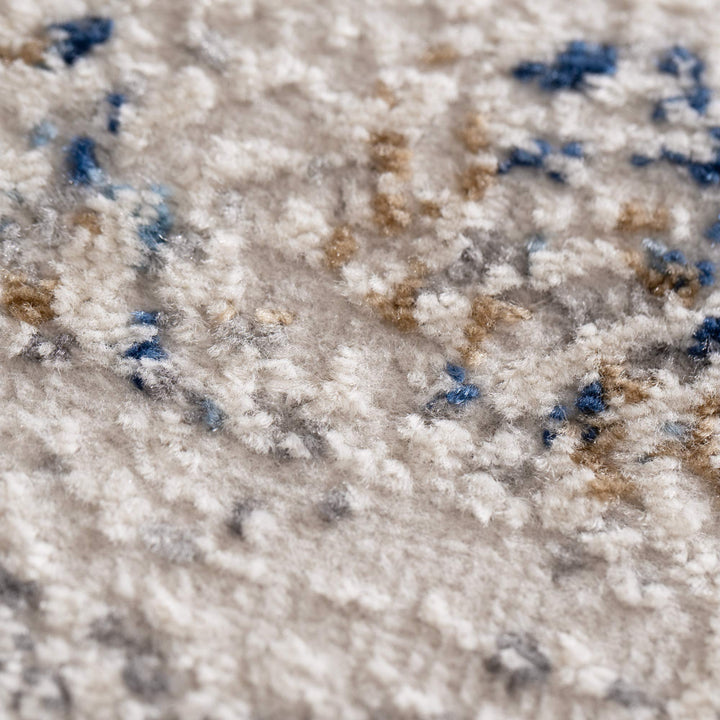Close-up of soft textured carpet with beige, blue, and brown abstract pattern