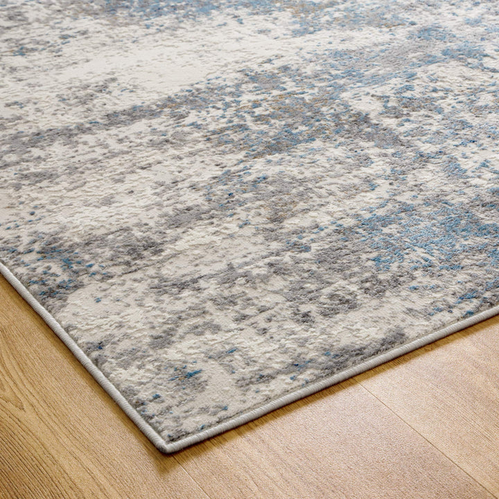 Modern area rug with blue and gray abstract pattern on light wood floor