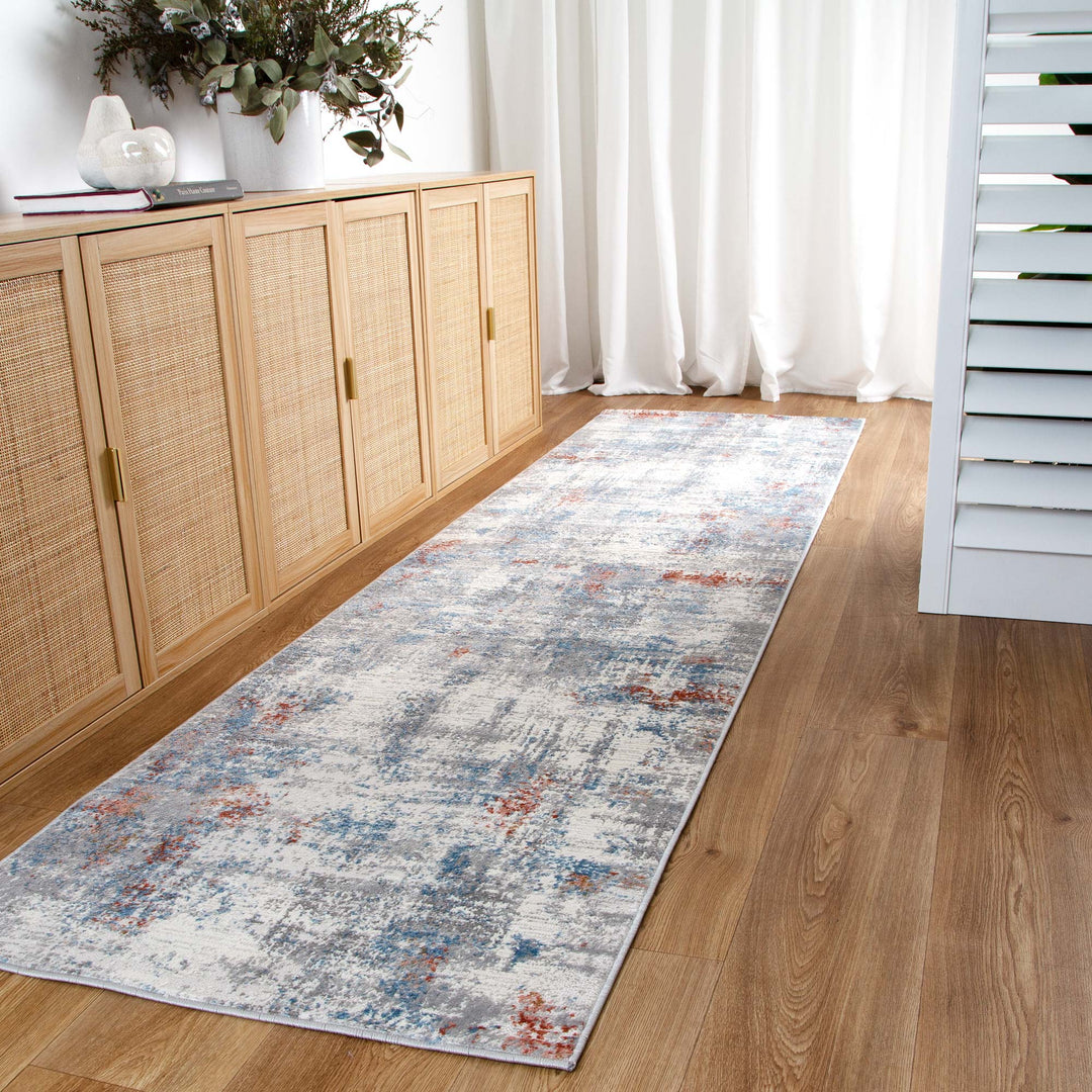 Modern hallway with light wood floor, abstract runner rug, rattan cabinet, and decorative vase