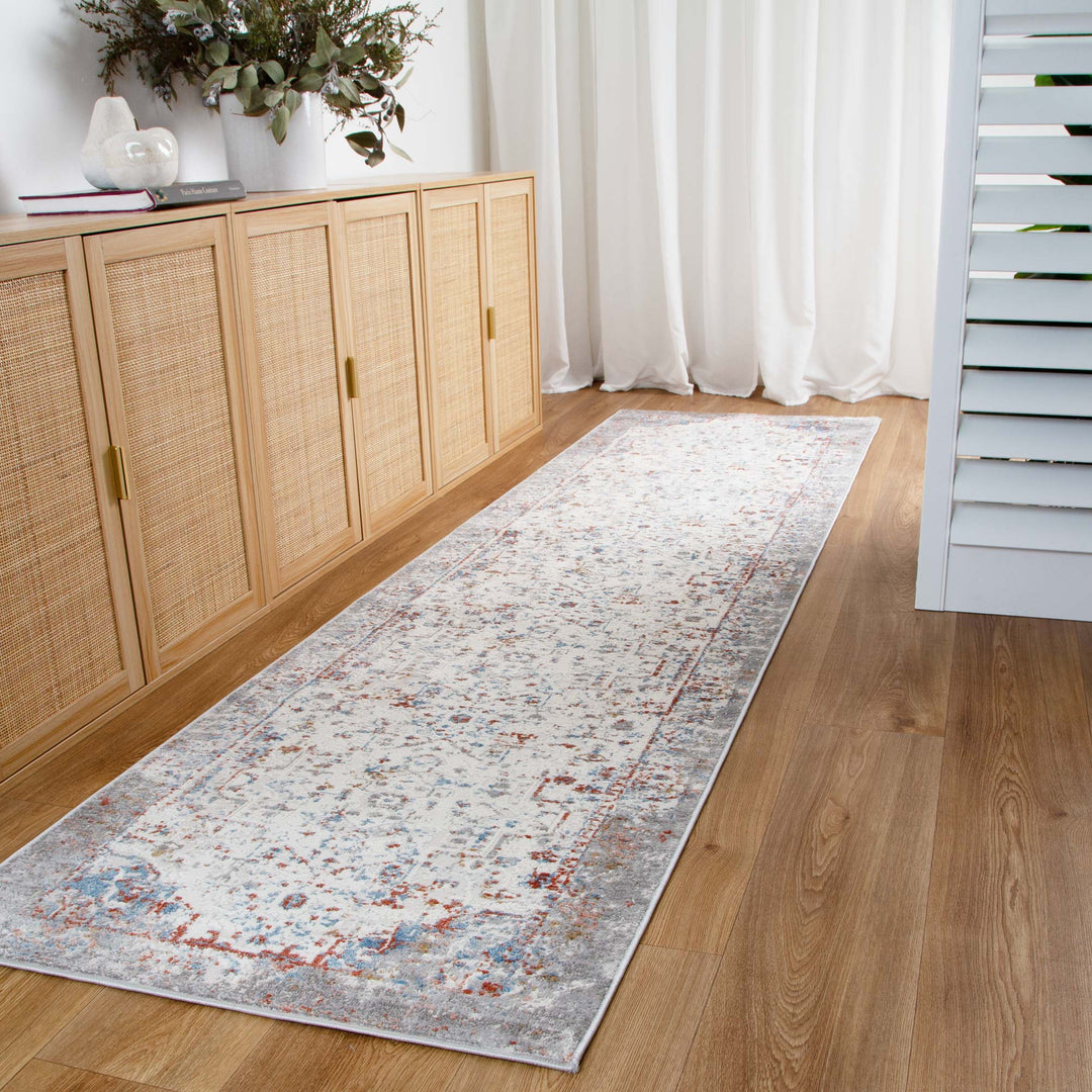 Long hallway runner rug with a distressed pattern on wooden floor, next to modern rattan cabinet.