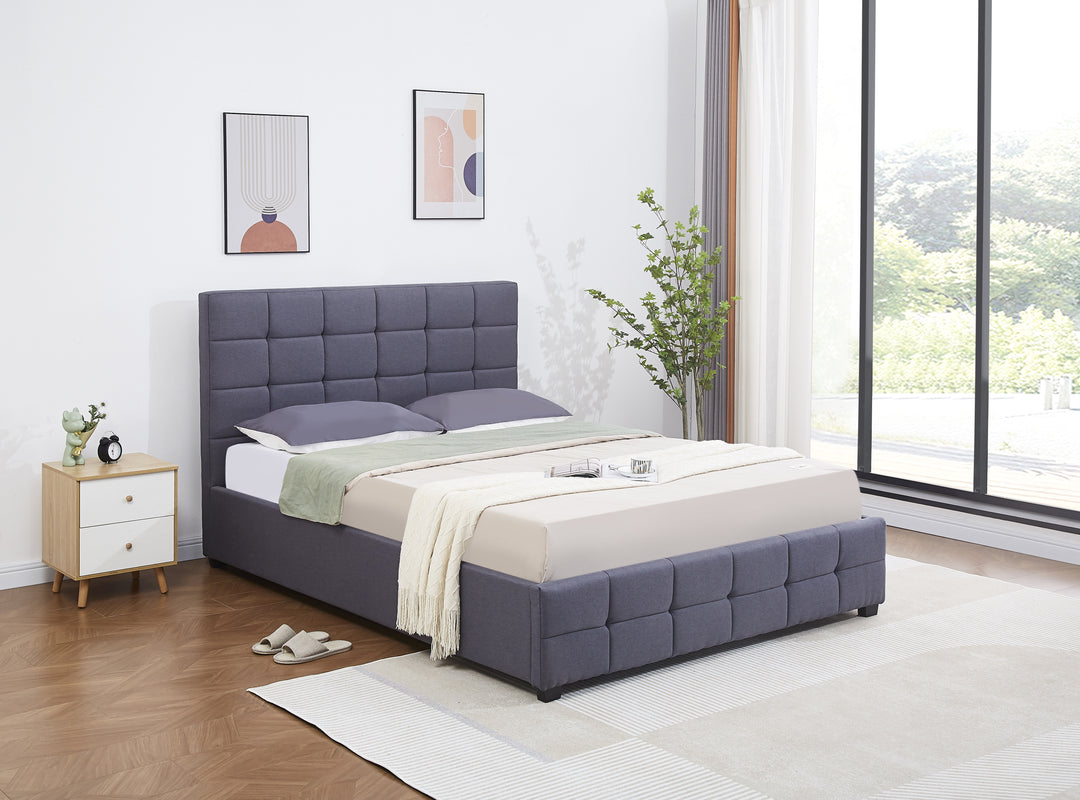 Modern grey upholstered bed with tufted headboard in a bright bedroom, wood floor, large window