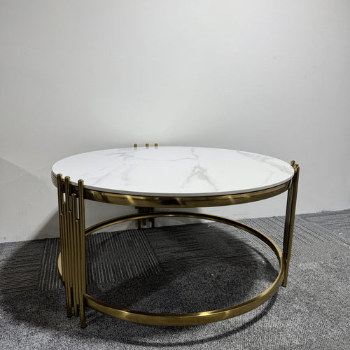 Round coffee table with white marble top and gold metal frame on grey carpet