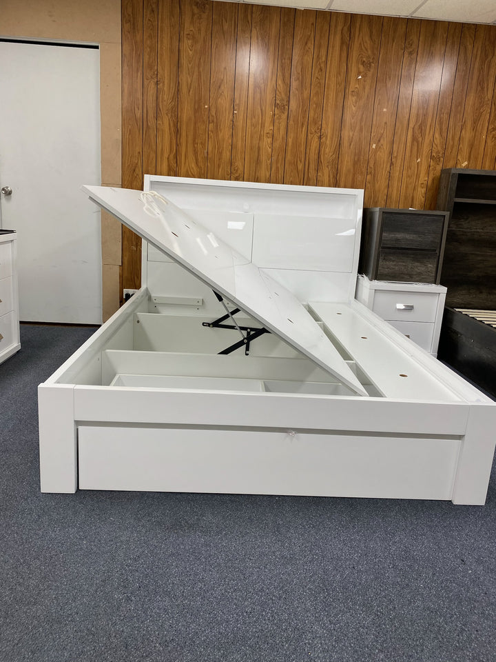 Modern white storage bed frame with lifted platform for underbed storage in showroom