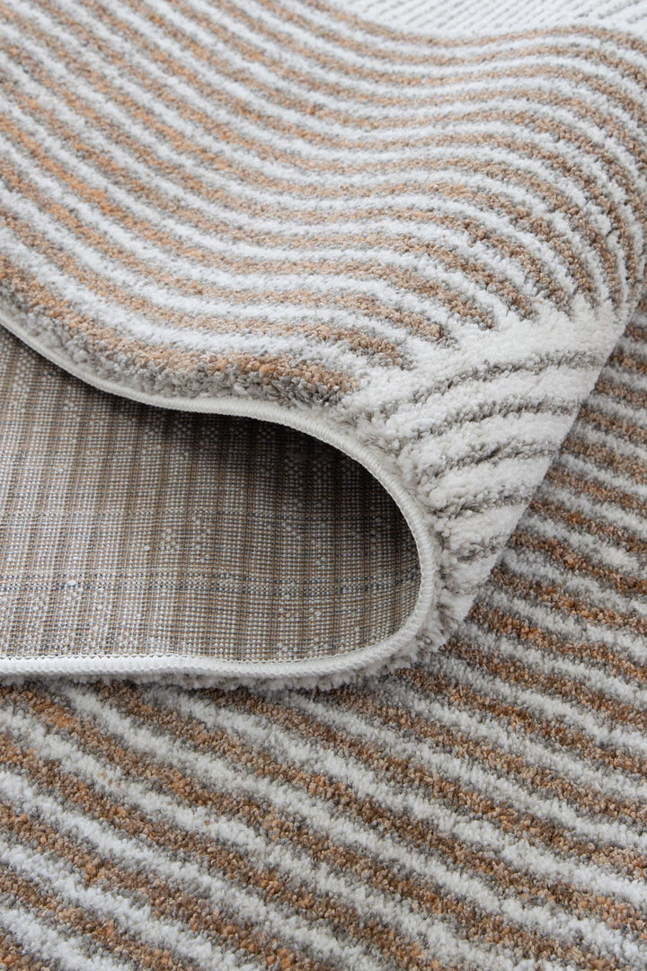 Close-up of a textured area rug with beige and white striped pattern and folded corner