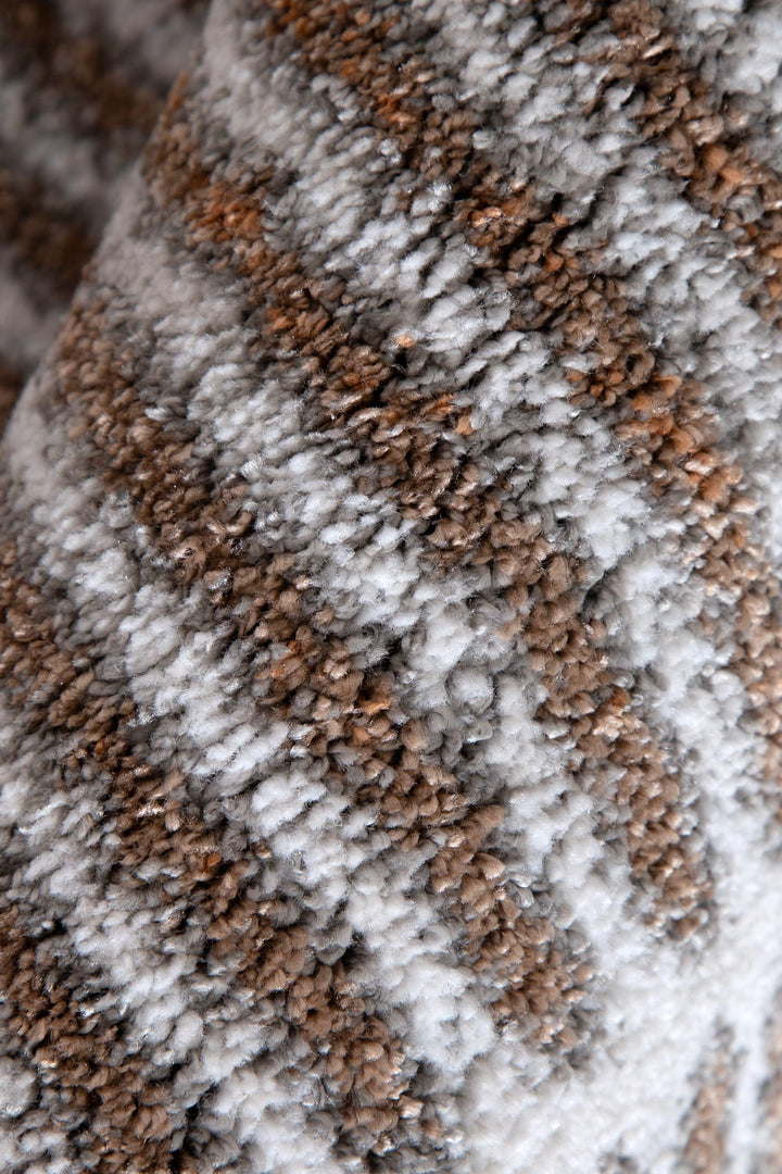 Close-up of soft, textured brown and gray patterned carpet or rug pile
