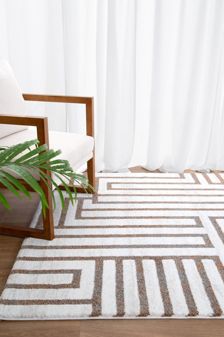 Modern armchair with wooden frame next to geometric patterned area rug on wood floor