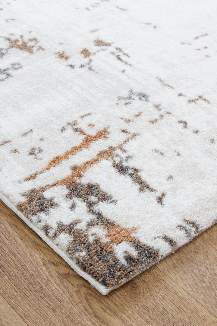 White area rug with abstract brown and gray pattern on wood floor