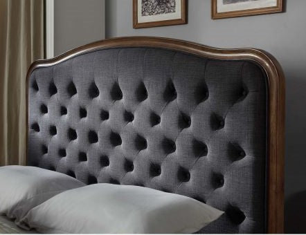 Upholstered dark grey tufted headboard with wooden frame in a modern bedroom setting