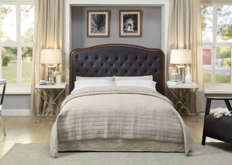 Modern bedroom with tufted dark headboard, beige bedding, bedside tables, and neutral decor.