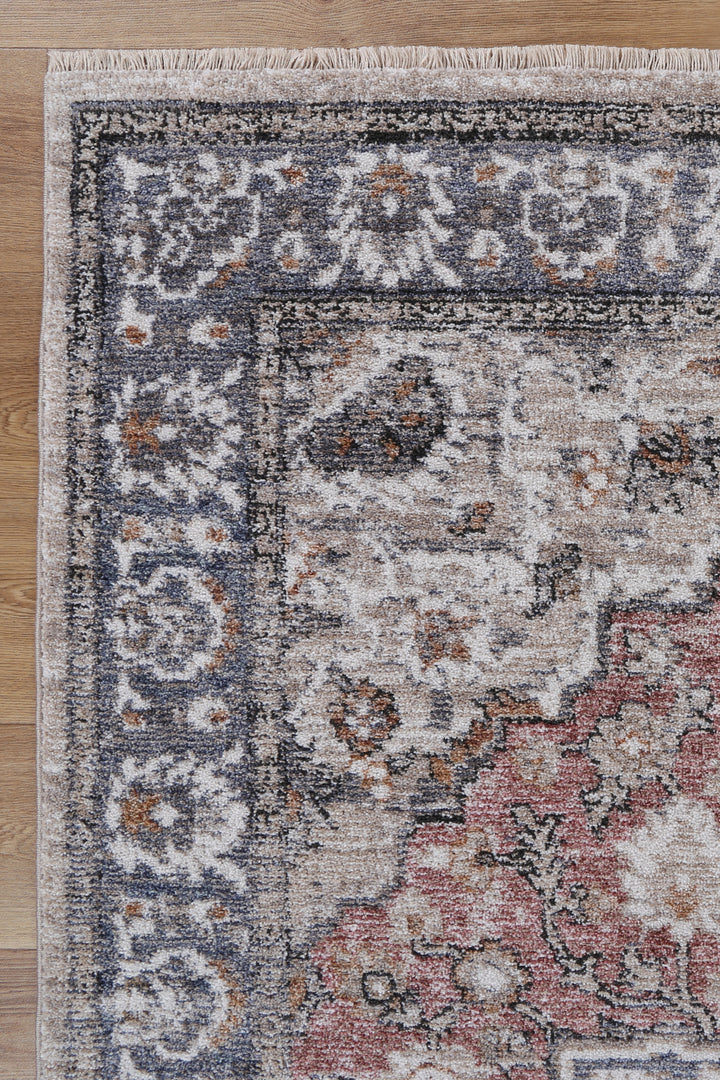 Vintage style area rug with floral border pattern on hardwood floor
